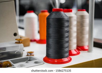 multi-colored bobbins with threads for sewing shoes at a large industrial plant close-up - Powered by Shutterstock