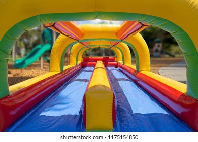Multi-colored bounce house open-air concept for all to see the happy kids at play.