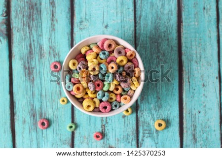 multicolored cereals in a white bowl on blue background