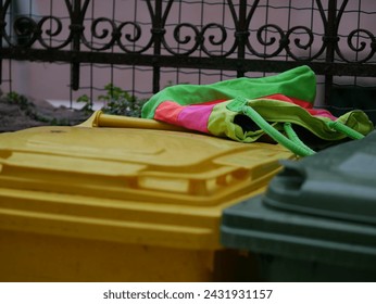 A multi-colored cloth bag lies on colored plastic trash cans. Second life of things. Rovinj, Croatia - February 27, 2024