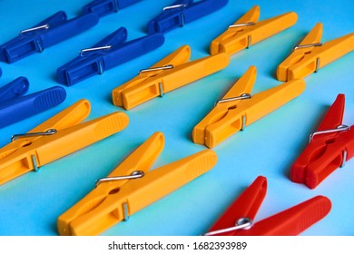 Multi-colored clothespins on a blue background lie in 3 rows.Bright objects.Perfectionism.Household.Close up.