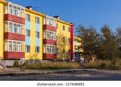 Multicolored colorful residential building in the northern town. View of a house painted yellow, red and blue. Ola urban-type settlement, Magadan region, Siberia, Russia.