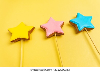 Multicolored Cookies On Sticks On A Yellow Background Cake Decorating Tools. Confectionery Concept. Top View. Close Up