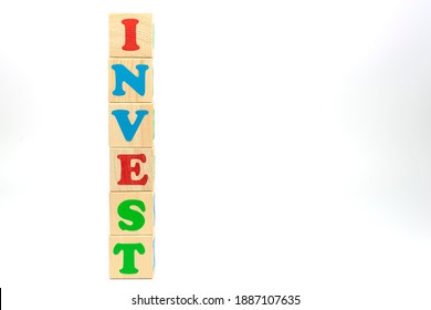 Multicolored cubes on white background word invest