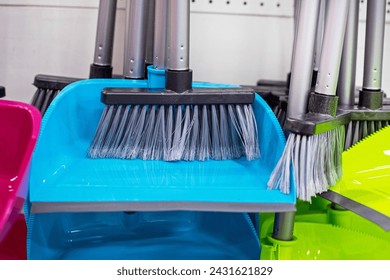 multi-colored dustpan and broom sets for cleaning in a supermarket display case - Powered by Shutterstock