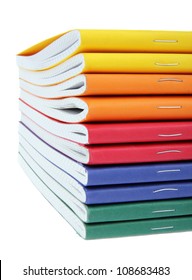 multicolored exercise books over the white background, close up.