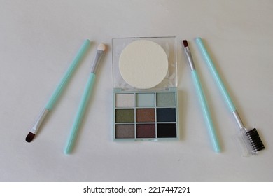 Multi-colored Eye Shadow, Blue Makeup Brushes, White Background