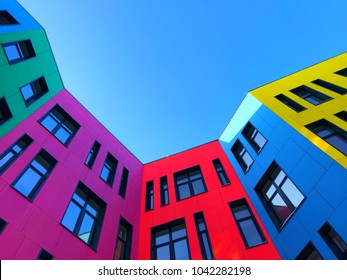 Multi-colored facades of the school with black window frames. Look up from the blue sky - Powered by Shutterstock