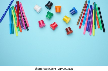 Multi-colored Felt-tip Pens And Acrylic Paint In A Plastic Jar On A Blue Background, Top View