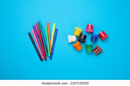 Multi-colored Felt-tip Pens And Acrylic Paint In A Plastic Jar On A Blue Background, Top View