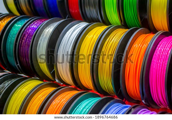 Multicolored filaments of plastic for printing\
on 3D printer close-up. Spools of 3D printing motley different\
colors thermoplastic filament. Motley ABS wire plastic for 3d\
printer. Additive\
technology