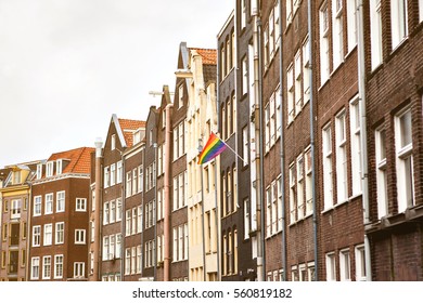 Multi-colored Flags On A House In Amsterdam In The Netherlands. European Sexual Revolution.