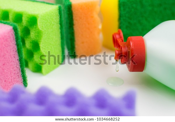 Multicolored foam rubber sponges and\
detergent on a light\
background.