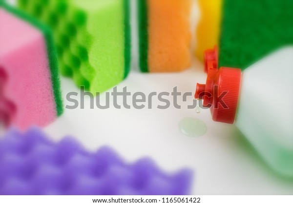 Multicolored foam rubber sponges and\
detergent on a light\
background.