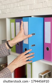 Multicolored Folders In The Office, A Woman Takes A Folder Of Documents From The Closet