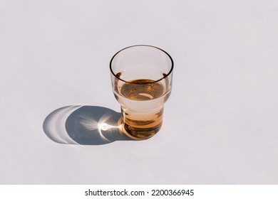 Multi-colored Green And Brown Glasses Filled With Water, Glare From Glass On A White Background