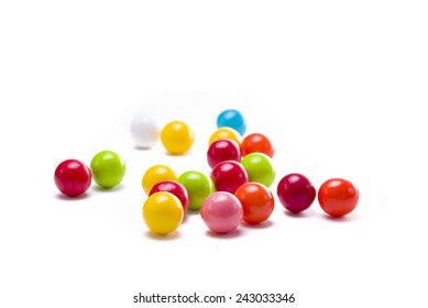 Multicolored gumballs sitting in a white background