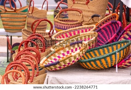 Multi-colored hand woven African baskets for sale at an outdoor market