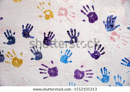 Multicolored handprints on the old wall.