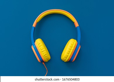 Multi-colored Headphones On Blue Background. Minimalistic Fashion Music Concept. Trendy Color Of The Year Concept. Top View, Flat Lay, Copy Space