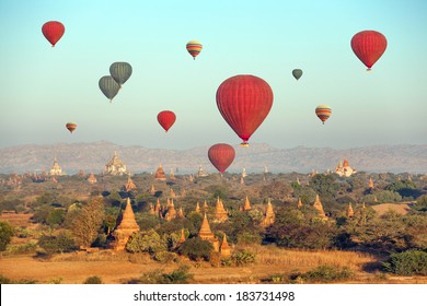 Multicolored hot air balloons over Buddhist temples at sunrise. Bagan, Myanmar. 
Canon 5D Mk II.

