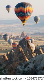 Multicolored hot-air balloons over Cappadocia rocks.