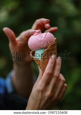 multicolored ice cream balls in a cup in hand