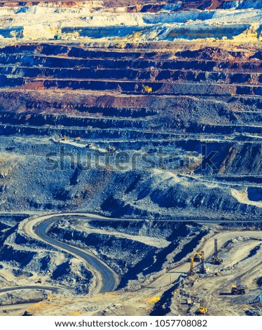 multicolored layers of rock in an open pit mining iron ore