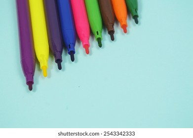 Multi-colored markers arranged in a row on a blue background, close-up. Markers for school and college. Art and education. colored markers for background - Powered by Shutterstock