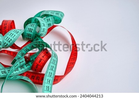 Multi-colored measuring tapes on a light background. Tool for measuring length and volume. Tape for measuring in sewing production or the volume of the human body