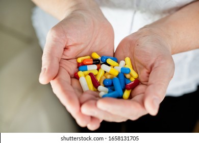 Multicolored Medical Capsules In The Palms Of An Older Woman