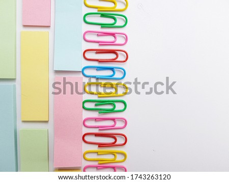 Multicolored metal paper clips on a white background.
