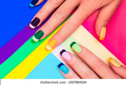 Multi-colored pastel manicure combined tone on tone with a striped background.Nail art.