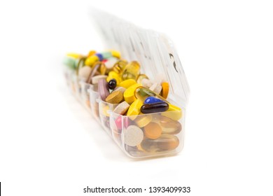 Multicolored Pills In And Around A Daily Pill Planner Dispenser