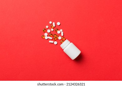 Multicolored pills and capsules in plastic bottle on Colored background, copy space. Many different various medicine tablets and pills, vitamin and nutritional supplements concept.