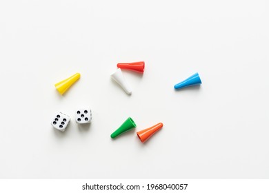 Multi-colored playing chips and dice cubes are grouped together on a white background: the concept of Board games, entertainment, background, games at home for the whole family