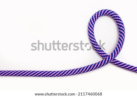 Multicolored rope with a loop on a white background. Strong rope with a curved shape with free space for text or advertising. Minimalism concept with blue pink rope on empty background