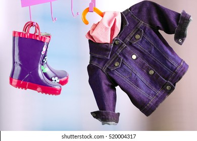 multi-colored  rubber boots for kids hanging with jeans denim jacket