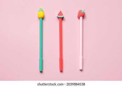 Multicolored school pens on pink background. Funny colorful Back to School concept - office and student supplies. Space for text. Early childhood education.  Flat lay. Top view of ballpoint pens.