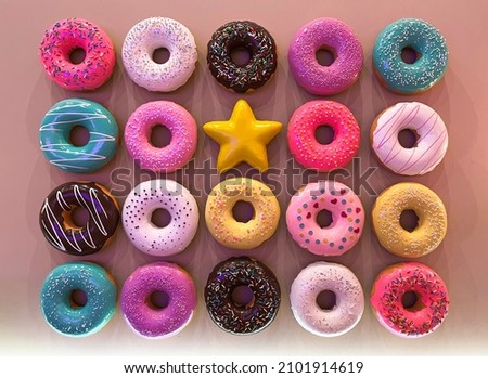 multicolored set of donuts with different powder on pink background, top view, gift or treat