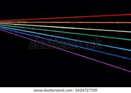 multicolored sewing threads in the form of a rainbow on a black background close-up