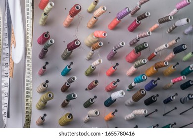 multi-colored sewing threads, in large quantities, in the sewing workshop, at an unusual viewing angle. Abstract background from threads