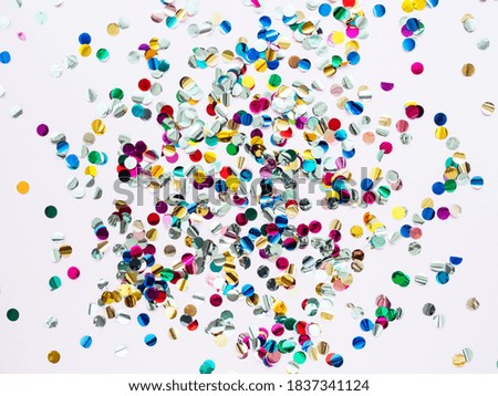 Multi-colored shiny round confetti on a pink background, top view, copy space, flat lay. Festive bright background. Minimalistic concept of New year, birthday or Christmas