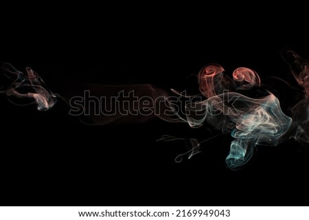 Multicolored smoke for aromatherapy and relaxation, black background, beautiful swirled puffs of smoke. Red, orange and turquoise gradient colors of dense smoke, decorative multi colour smoke curls