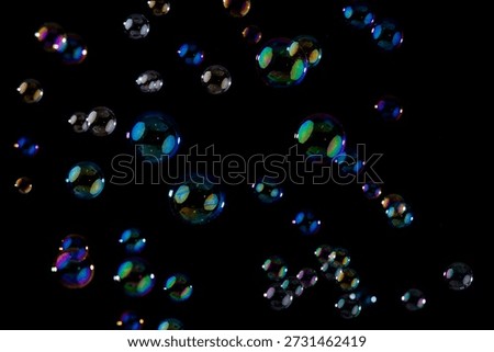 Multicolored Soap Bubbles Floating Against a Solid Black Background