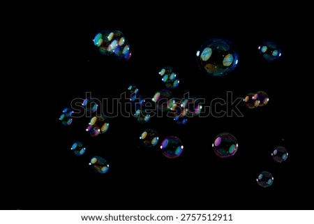 Multicolored Soap Bubbles Floating Against a Solid Black Background