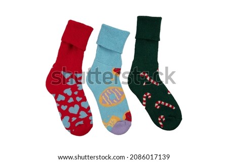 Multi-colored socks on a white background. View from above. Many different socks for cold seasons. Socks are scattered on a bright background. Socks of different types and sizes.