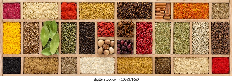 Multicolored spices in a wooden organizer, top view. Seasoning background