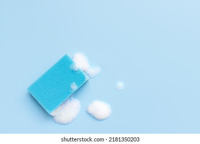 Multicolored sponges for cleaning on a blue background. Space for text
