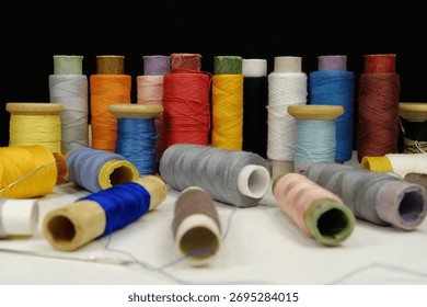 Multicolored spools thread. Spools of multi-colored threads lies on white table